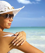 Woman applying sunscreen to her shoulder. - Copyright – Stock Photo / Register Mark